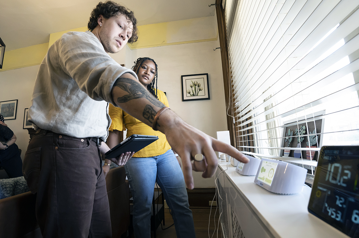 Jemima Ohwobete, a PhD student and researcher in the Department of Civil and Environmental Engineering, Swanson School of Engineering, works with Joseph Engelmeier, an environmental health researcher and graduate student in the School of Public Health, to review the indoor air quality devices at the Healthy Home Lab.